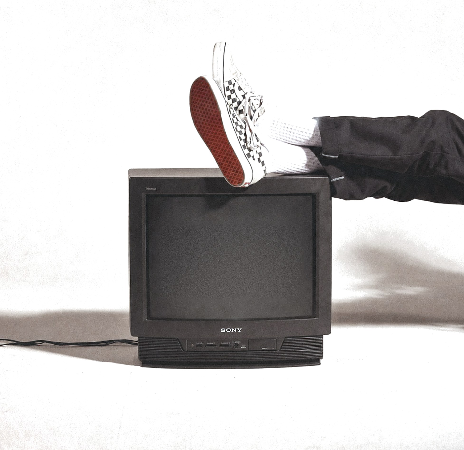 A pair of sneakers resting on an old Sony television